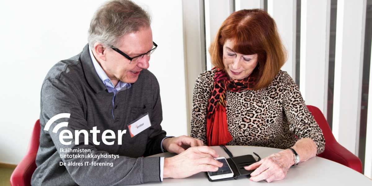 Kaksi senioria tutkii kännykkää.